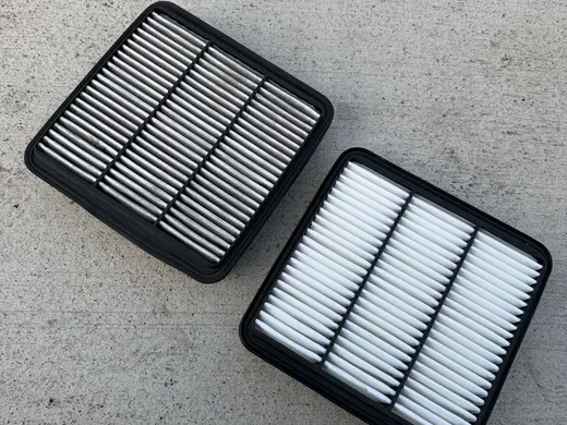 New engine air filter next to the dirty one removed from a customer car