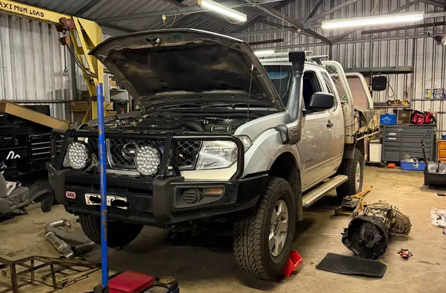 Nissan Navara with the bonnet up during a mechanical repair in the workshop