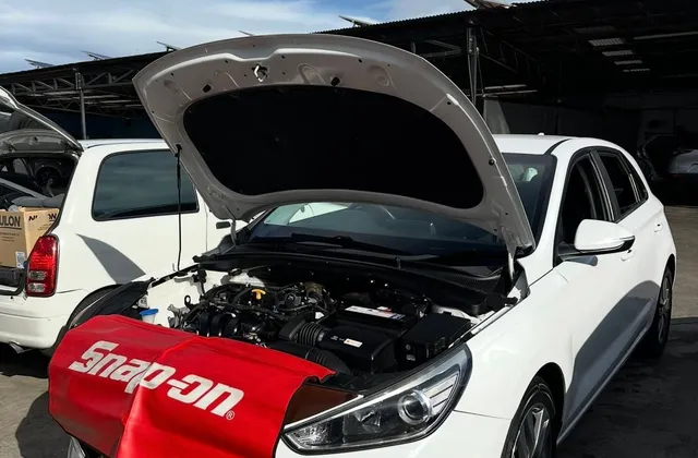Mobile car service on a Hyundai i30, bonnet up with fender cover fitted