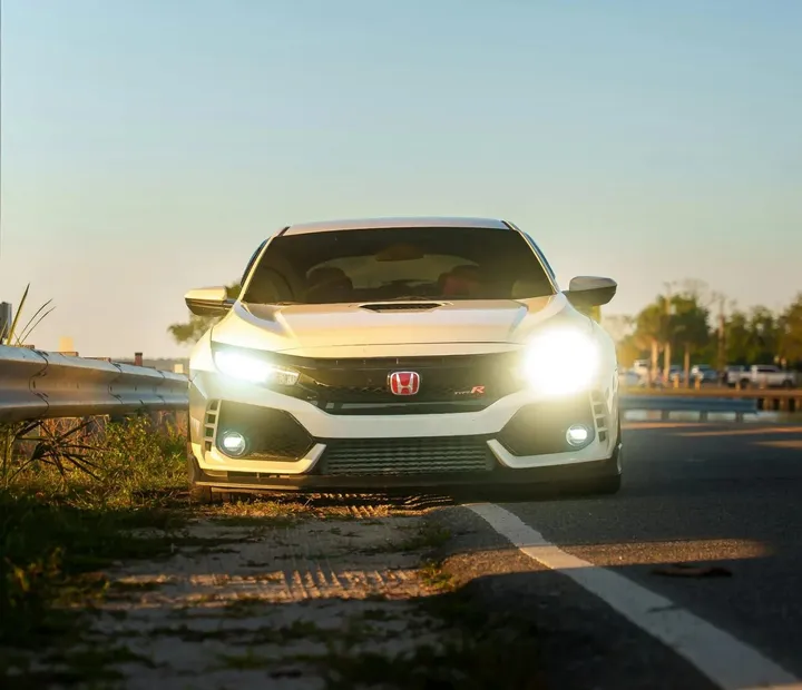 Car at dusk on a Sydney roadside with its headlights on — RSG Mechanical roadside assistance