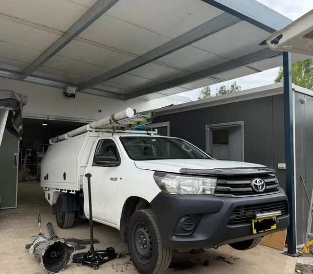 RSG Mechanical repairing a Toyota Hilux ute under a customer's carport